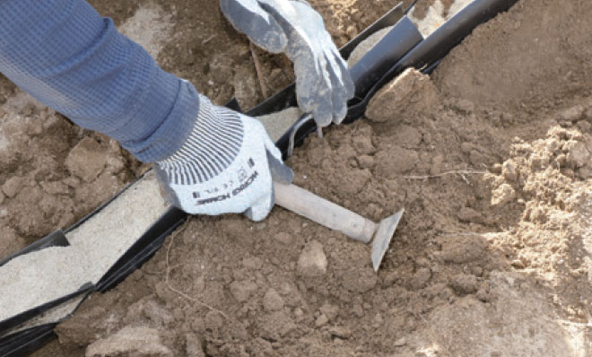 埋設溝を土寄せして押し固め、ホルダーを固定する